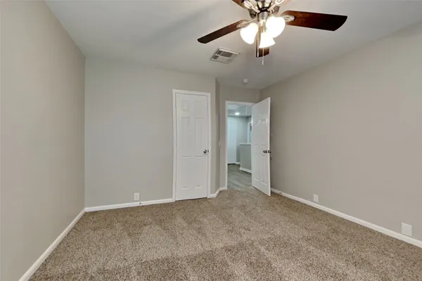 an empty room with closet and a chandelier fan