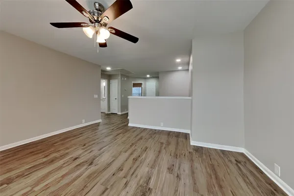 a view of an empty room with wooden floor
