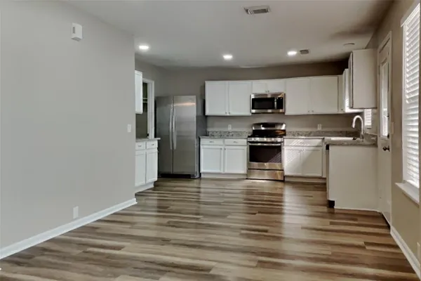 a kitchen with stainless steel appliances granite countertop a refrigerator and a stove top oven