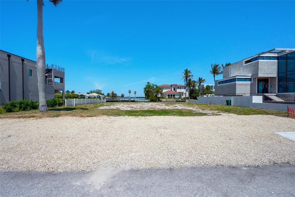 581 Rountree Drive Longboat Key, FL 34228 - Photo 14 of 50 a view of a house with a yard and a car park
