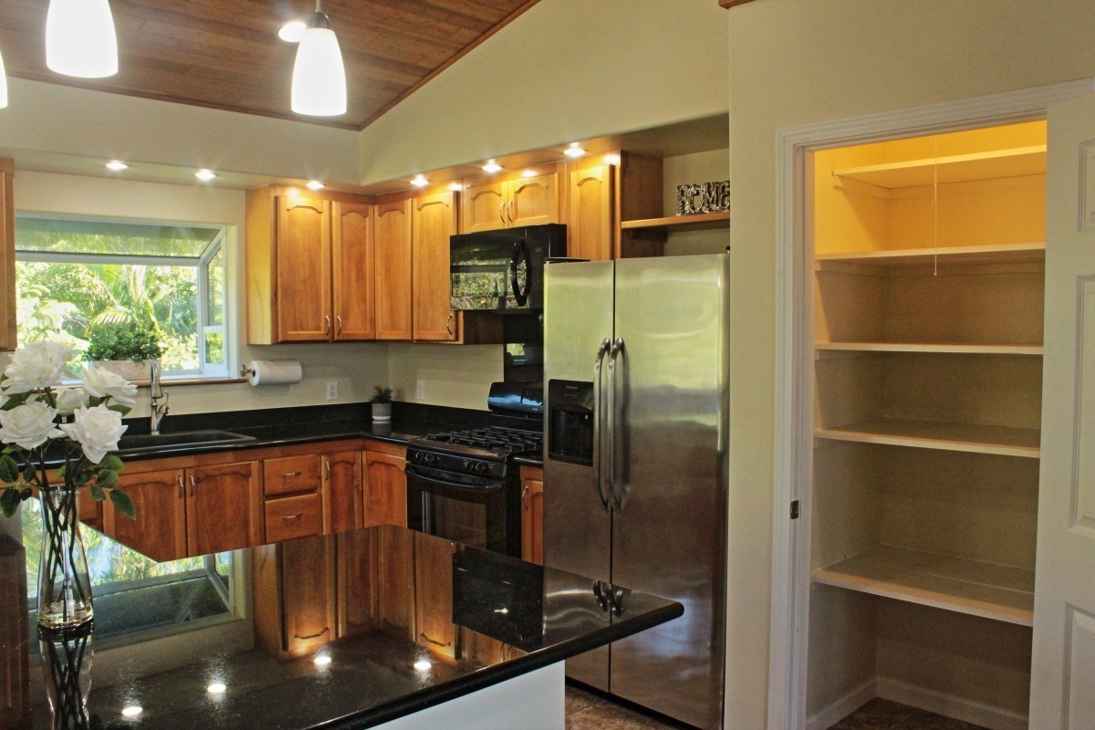 18-1354 Nichols Rd Mountain View Mountain View, HI 96771 - Photo 7 of 30 a kitchen with stainless steel appliances granite countertop a refrigerator and a sink