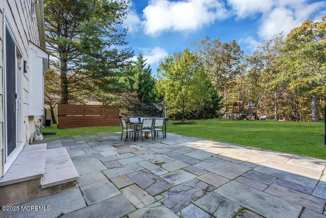 an aerial view of residential house with outdoor space and trees all around