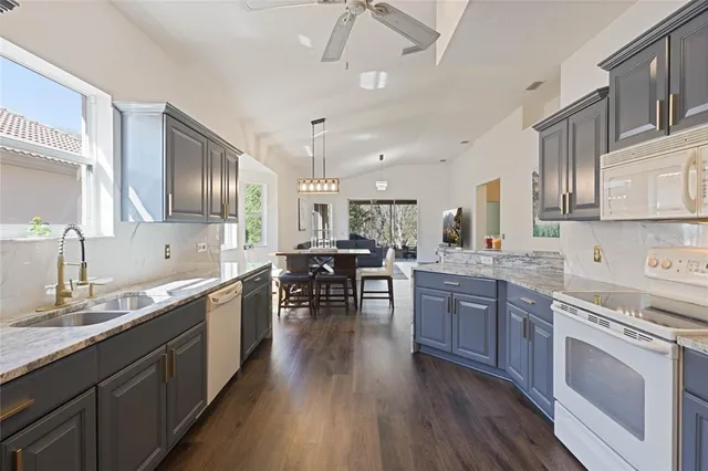 a large kitchen with stainless steel appliances granite countertop a lot of counter space and wooden floors