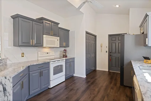 a kitchen with stainless steel appliances granite countertop a refrigerator and a stove top oven