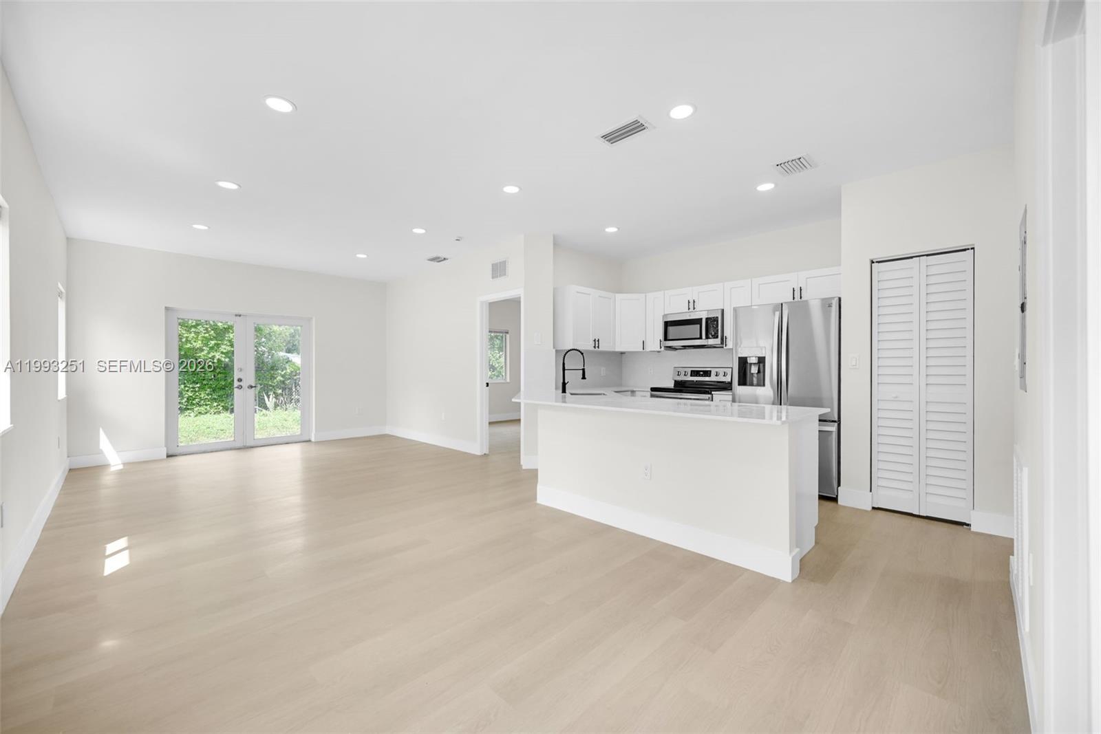 6940 Northwest 5th Place Miami, FL 33150 - Photo 11 of 42 a view of kitchen with stainless steel appliances refrigerator oven and white cabinets with wooden floor