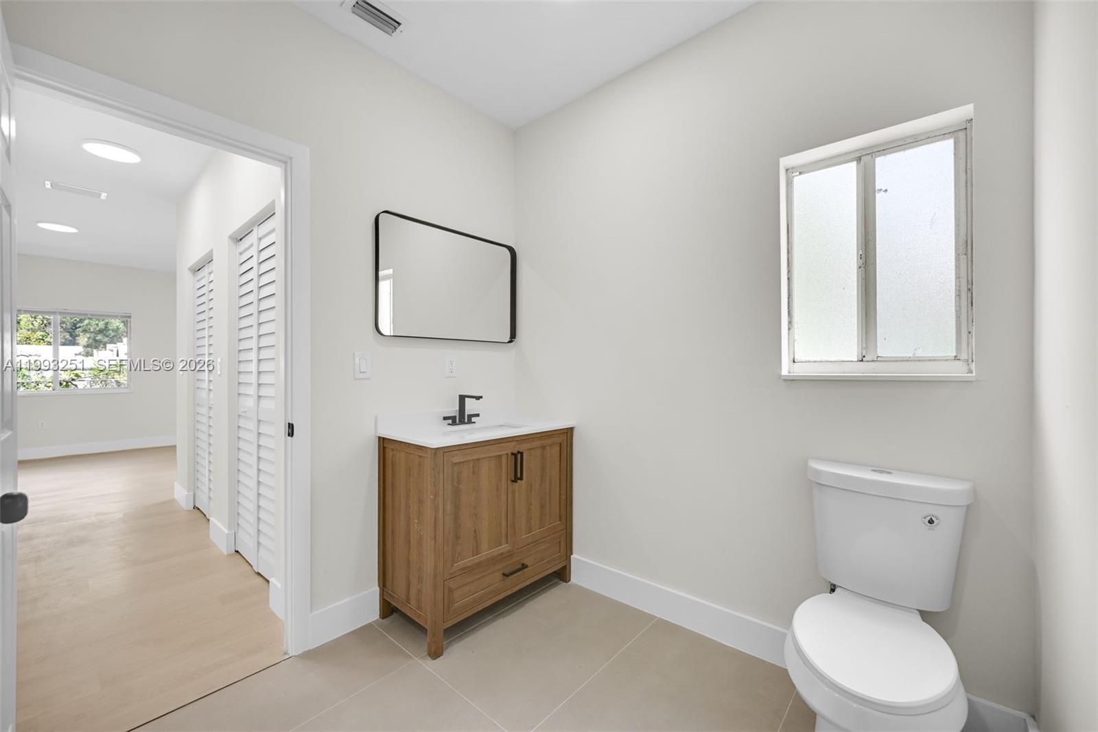 6940 Northwest 5th Place Miami, FL 33150 - Photo 28 of 42 a spacious bathroom with a toilet sink and mirror