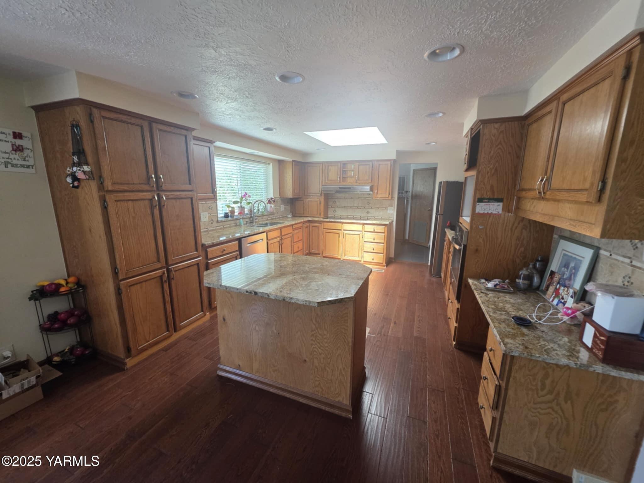 5202 Norman Road Yakima, WA 98901 - Photo 25 of 48 a kitchen with stainless steel appliances granite countertop a refrigerator a stove a sink dishwasher and a refrigerator with wooden floor