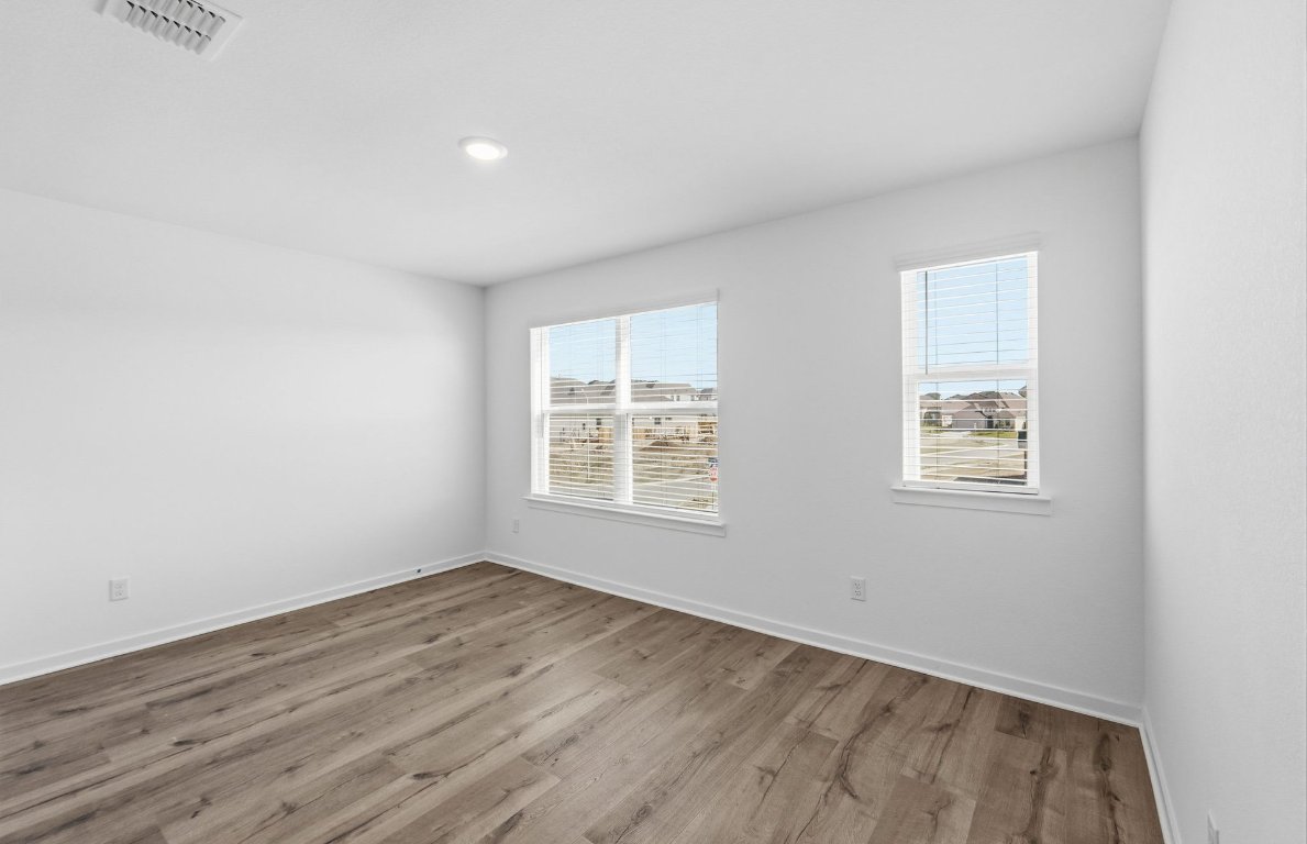 290 Begonia Street Buda, TX 78610 - Photo 15 of 25 an empty room with wooden floor and windows