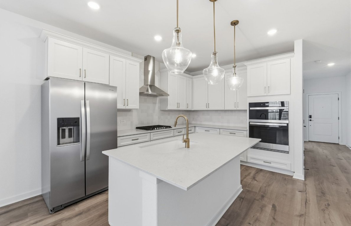 290 Begonia Street Buda, TX 78610 - Photo 4 of 25 a kitchen that has a lot of cabinets and stainless steel appliances