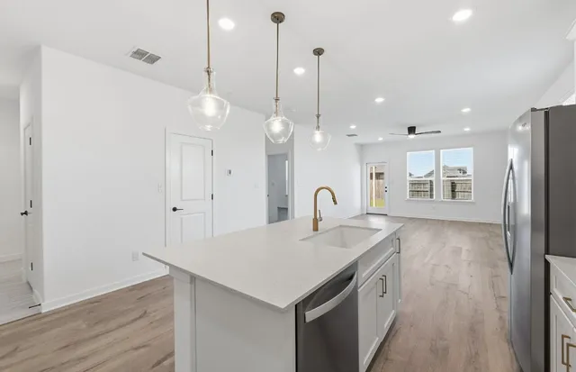 a kitchen with a sink a stove a refrigerator and wooden floor