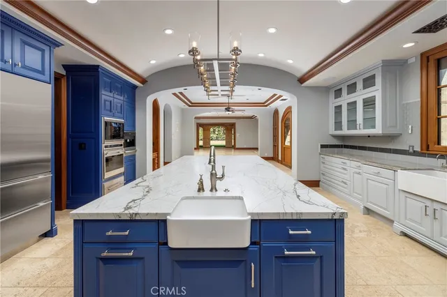 a kitchen with a stove a kitchen island a sink and a refrigerator