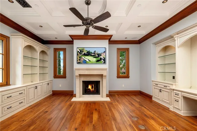 a view of a livingroom with wooden floor and a kitchen