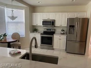 a kitchen with stainless steel appliances a stove a sink cabinets and a refrigerator