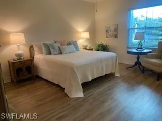 a bedroom with a bed a table with wooden floor