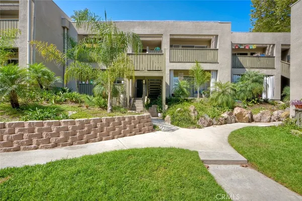 a view of house with a yard and potted plants