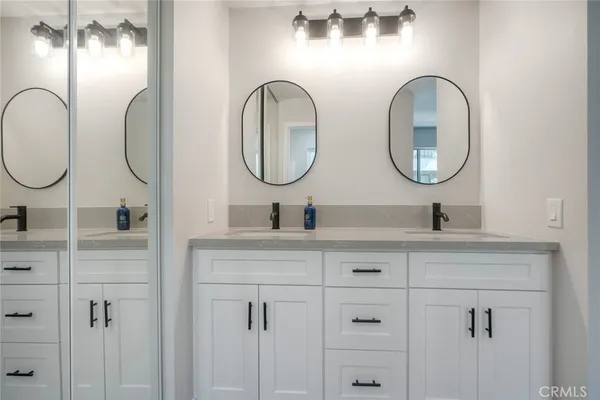 a bathroom with a double vanity sink and a mirror