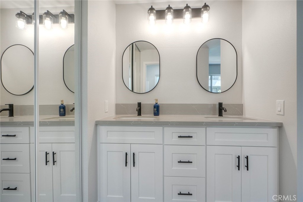 149 West Glaucus Street, Unit D Encinitas, CA 92024 - Photo 16 of 29 a bathroom with a double vanity sink and a mirror