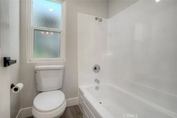 a white toilet sitting next to a tub