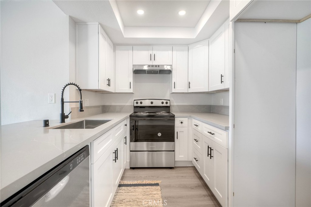 149 West Glaucus Street, Unit D Encinitas, CA 92024 - Photo 6 of 29 a kitchen with stainless steel appliances granite countertop a stove and a sink