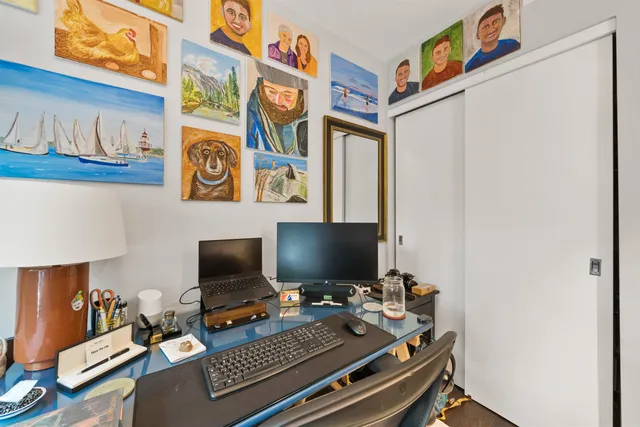 a laptop computer sitting on top of a work place with a desk and chair