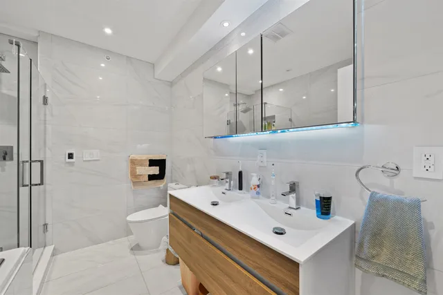 a bathroom with a sink mirror vanity and toilet
