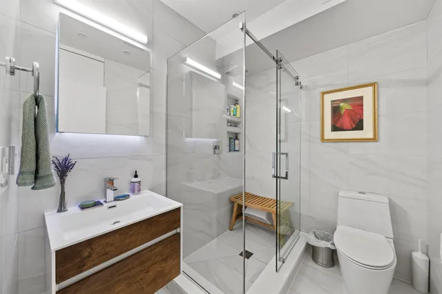 a bathroom with a sink a toilet and shower