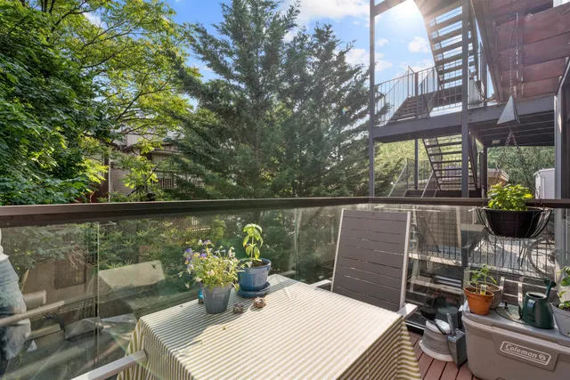 a view of a balcony with chairs and a potted plant