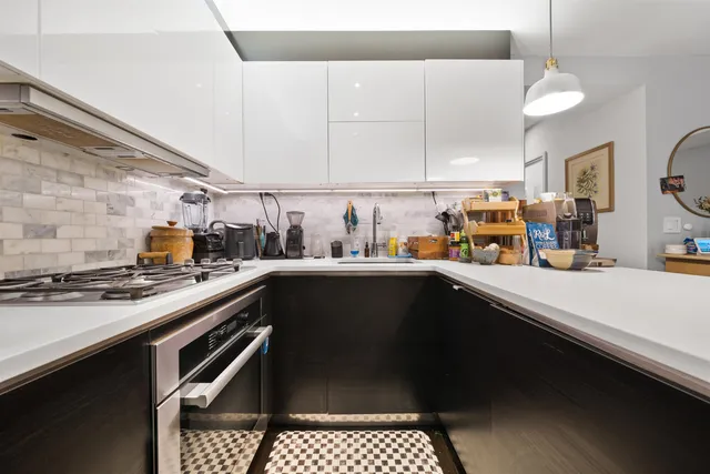 a kitchen with a sink a stove and cabinets