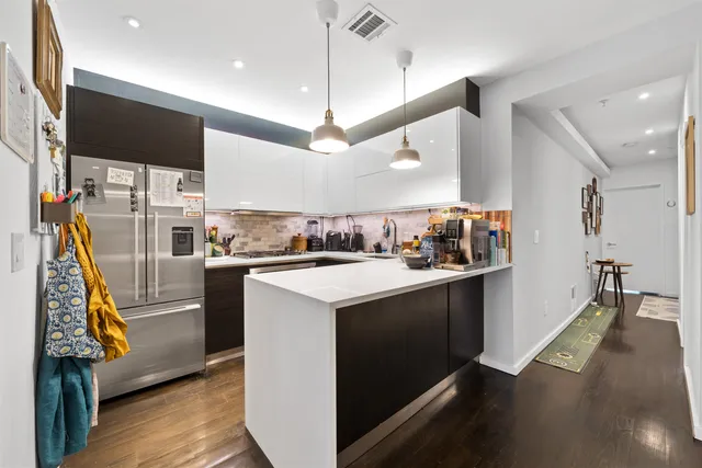 a kitchen with stainless steel appliances granite countertop a sink and a refrigerator