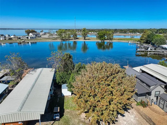 an aerial view of ocean and residential houses with outdoor space