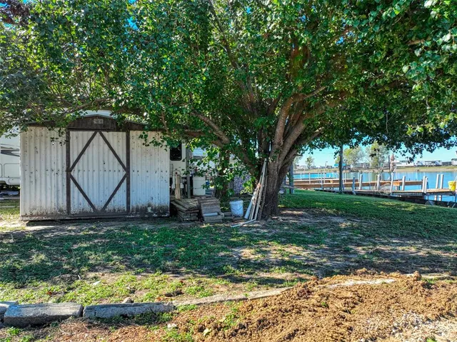 a view of a yard with a tree and a wooden fence