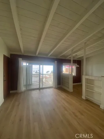 a view of empty room with window and wooden floor