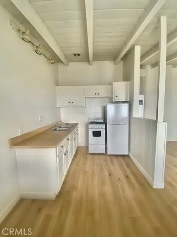 a kitchen with cabinets and a stainless steel refrigerator