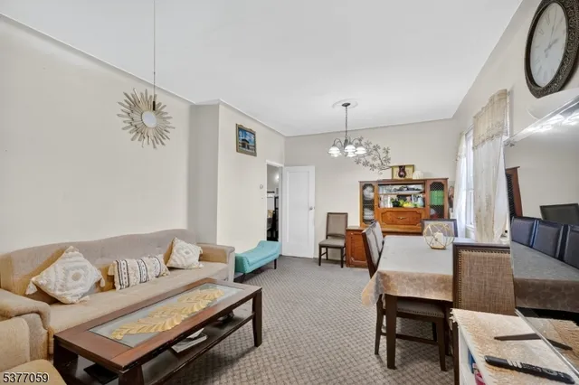 a living room with furniture a dining table and a chandelier