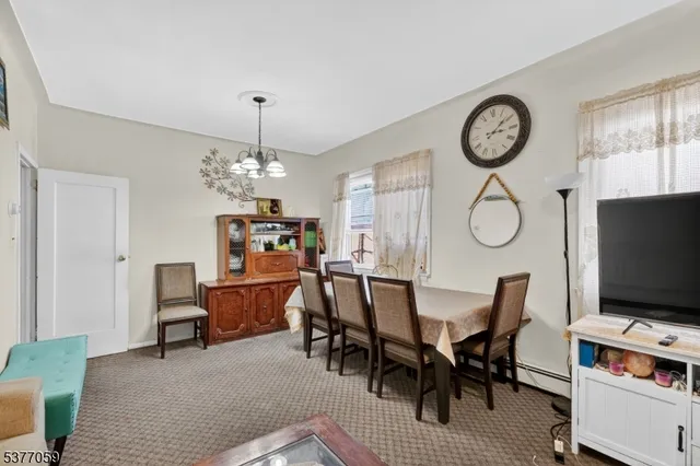 a view of a dining room with furniture a chandelier and a rug