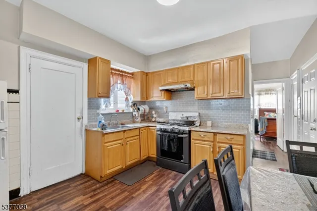 a kitchen with stainless steel appliances granite countertop a stove a sink dishwasher and a refrigerator
