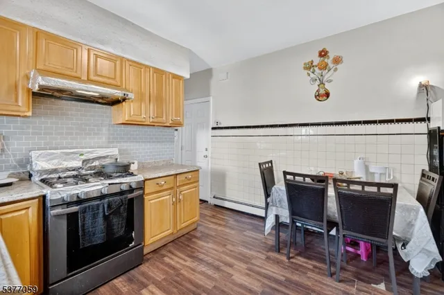 a kitchen with stainless steel appliances a stove a sink cabinets and a dining table