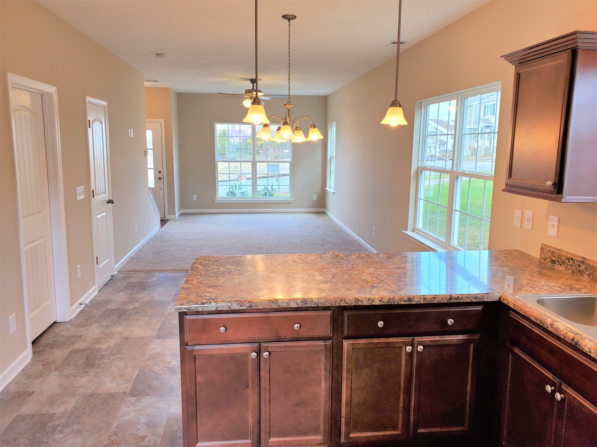 a room with kitchen island granite countertop wooden cabinets a counter top space and stainless steel appliances