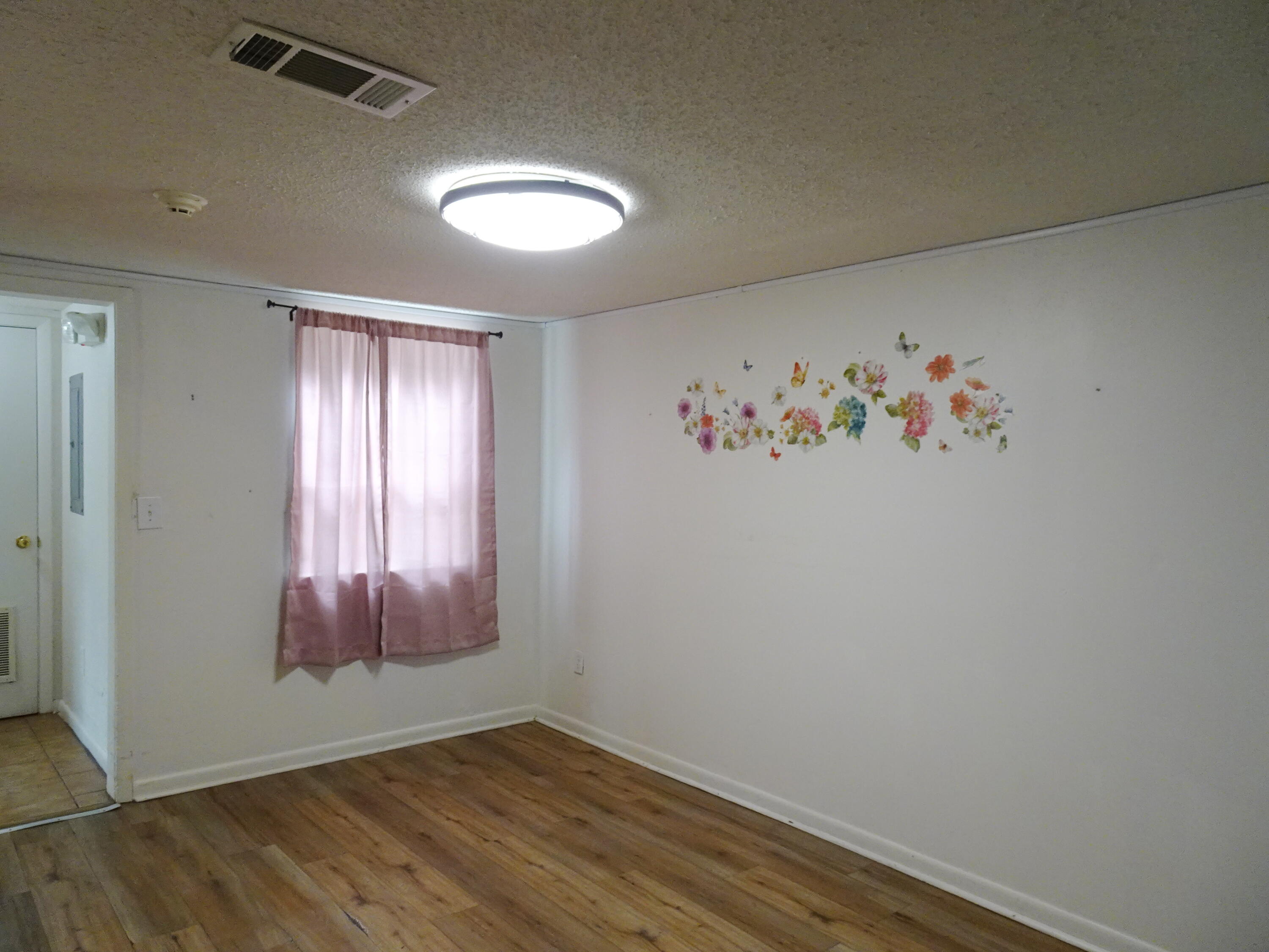 195 Heather Lane DeFuniak Springs, FL 32433 - Photo 5 of 20 an empty room with wooden floor and windows