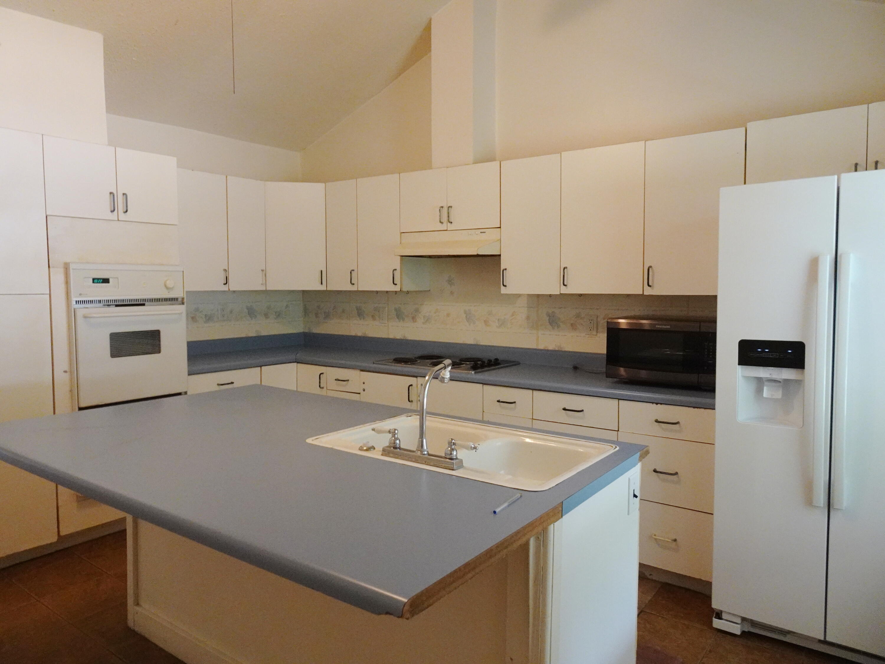 195 Heather Lane DeFuniak Springs, FL 32433 - Photo 6 of 20 a kitchen with a sink a stove a refrigerator and white cabinets