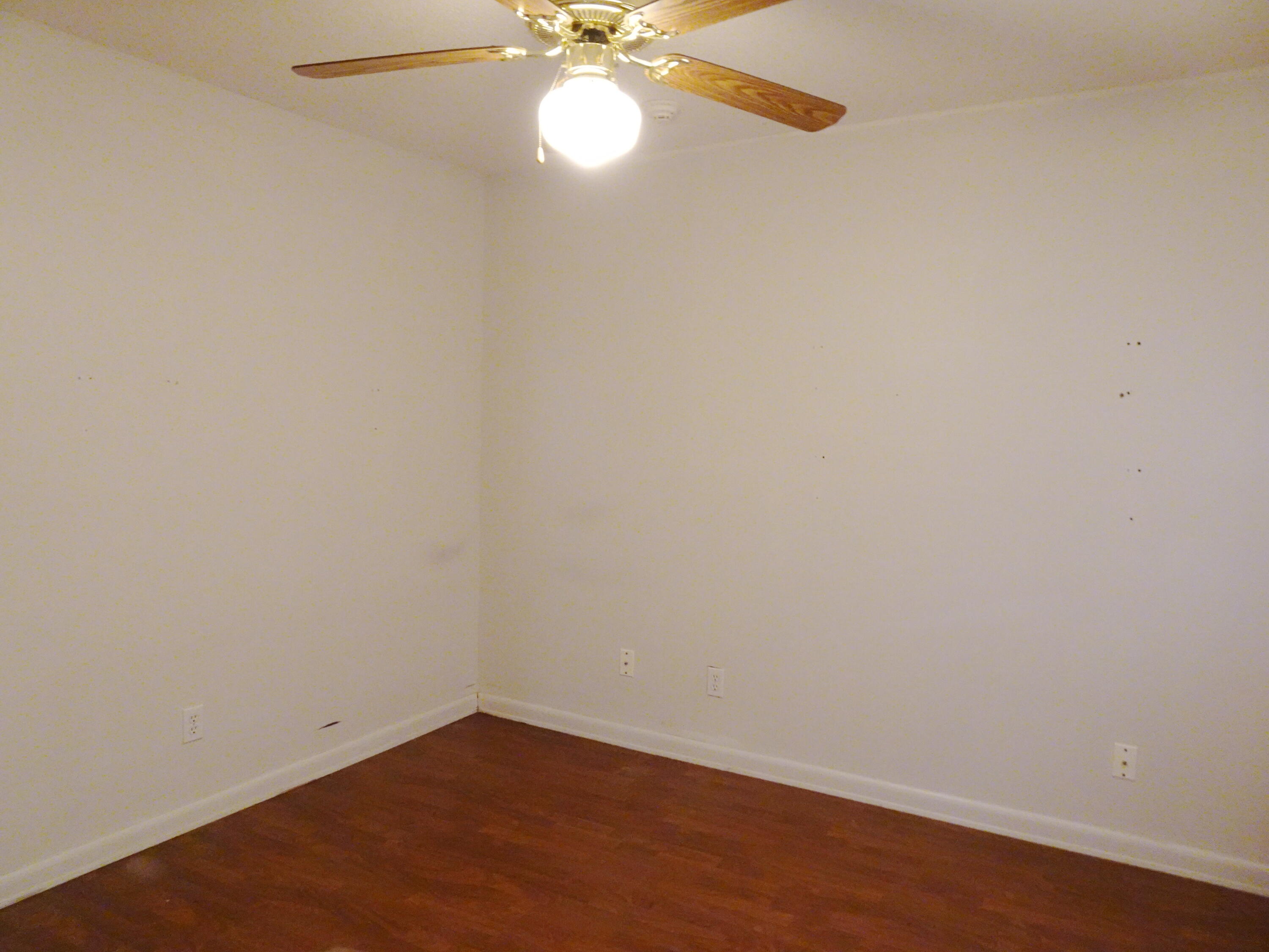 195 Heather Lane DeFuniak Springs, FL 32433 - Photo 10 of 20 an empty room with a chandelier fan and wooden floor