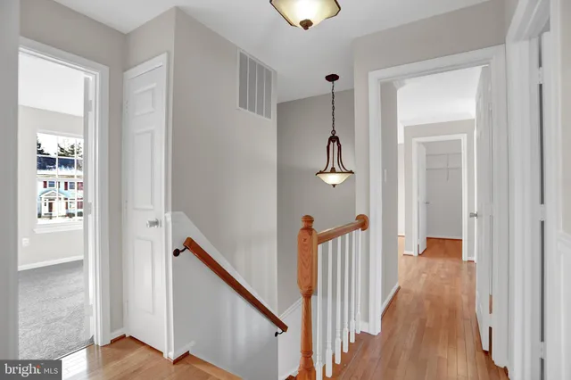 a view of a hallway with wooden floor and staircase