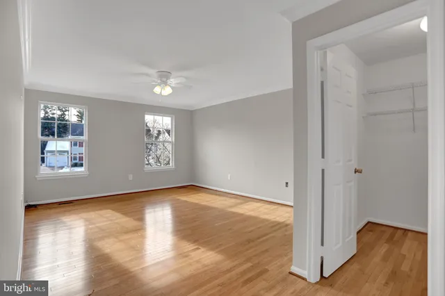 a view of an empty room with window and wooden floor