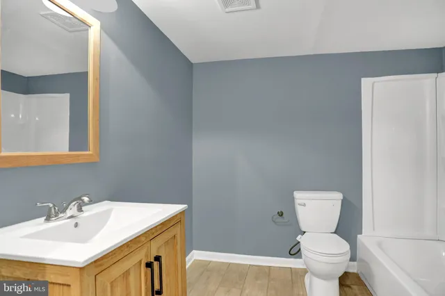a bathroom with a sink a toilet and a mirror