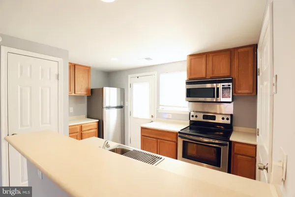 a kitchen with stainless steel appliances a refrigerator and a stove top oven