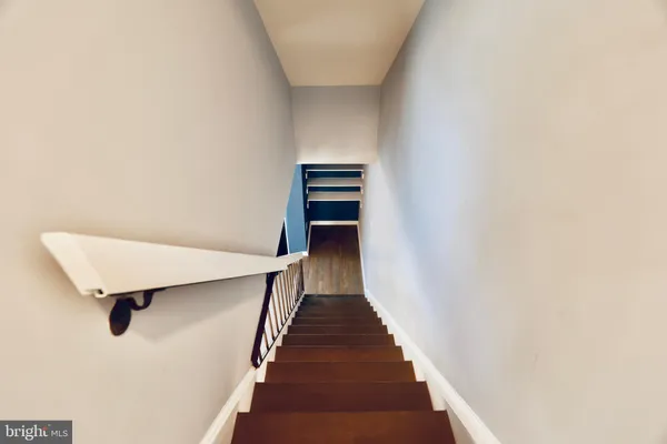 a view of a hallway with wooden floor and staircase