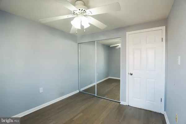 an empty room with closet and a ceiling fan