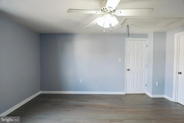 an empty room with a ceiling fan and wooden floor