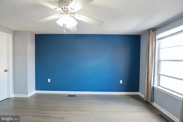 an empty room with windows and fan