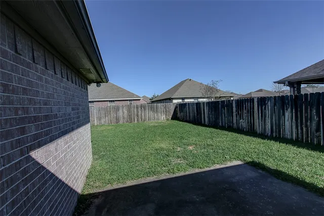 a view of a backyard with wooden fence
